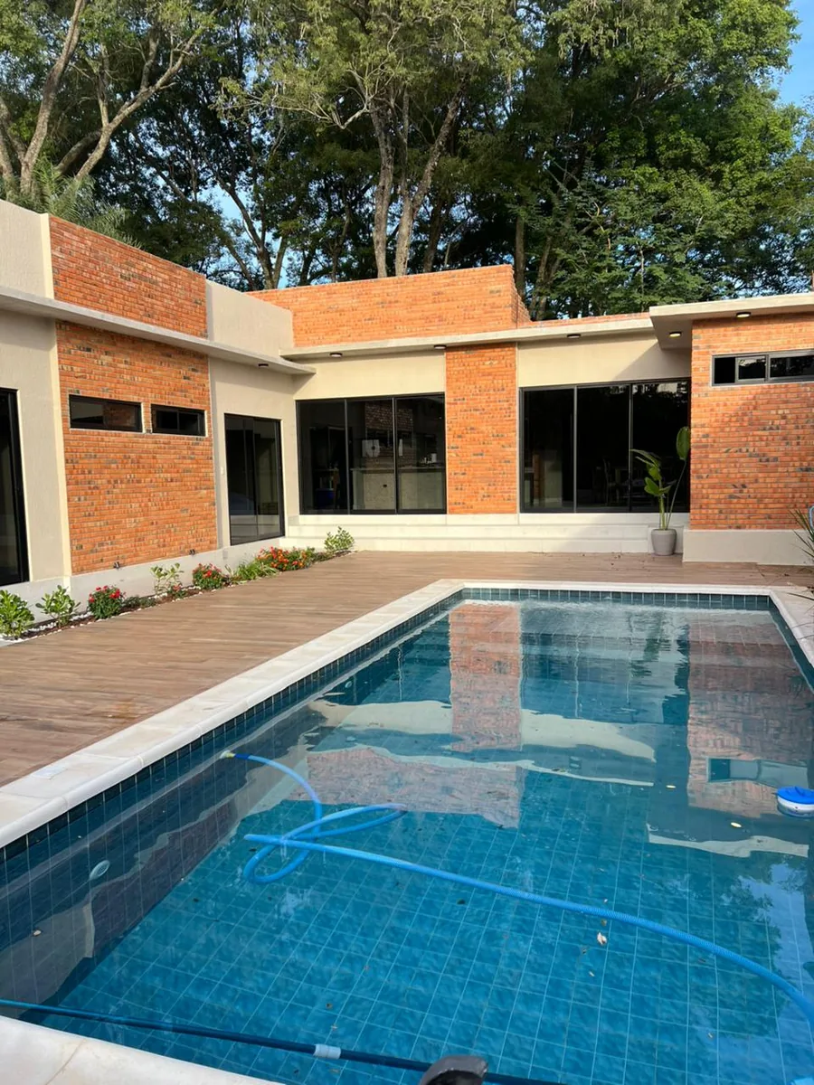 Piscina y patio junto a una construcción de ladrillos